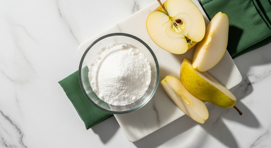 Fruktose Pulver in Glasschale neben frischem Obst